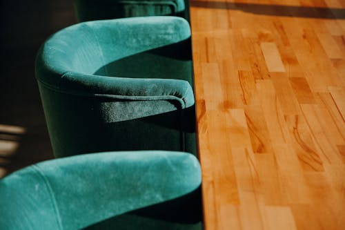 Close-Up Photo Of Padded Chairs And A Wooden Table