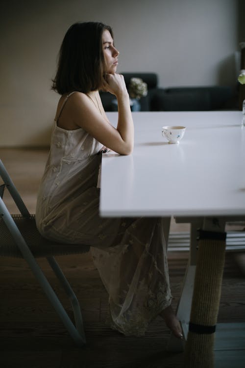 A Woman Sitting on a Chair while in Deep Thoughts