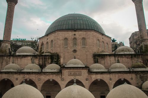 Free Discover the detailed architecture of a historic mosque in Şanlıurfa, Türkiye with its prominent domes. Stock Photo