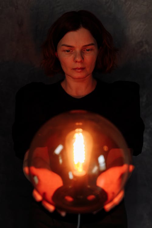 Free A Woman Holding a Lamp Stock Photo
