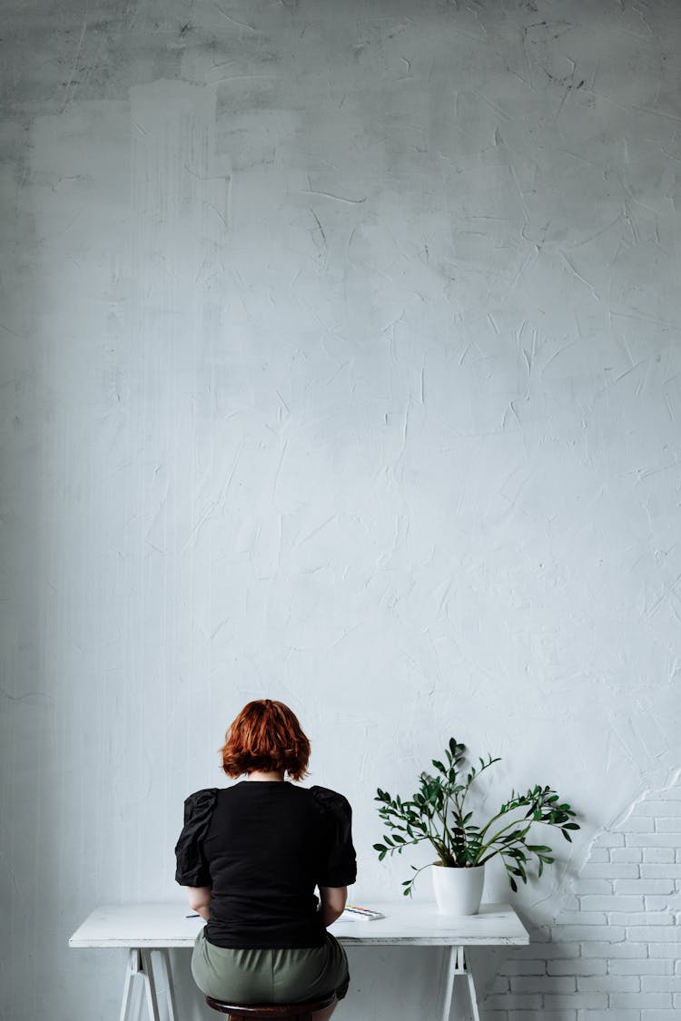 A Person Sitting While Facing The Wall