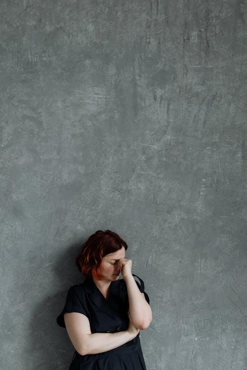 A Stressed Woman Leaning on the Wall