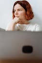 Woman in White Shirt Leaning on Gray Table