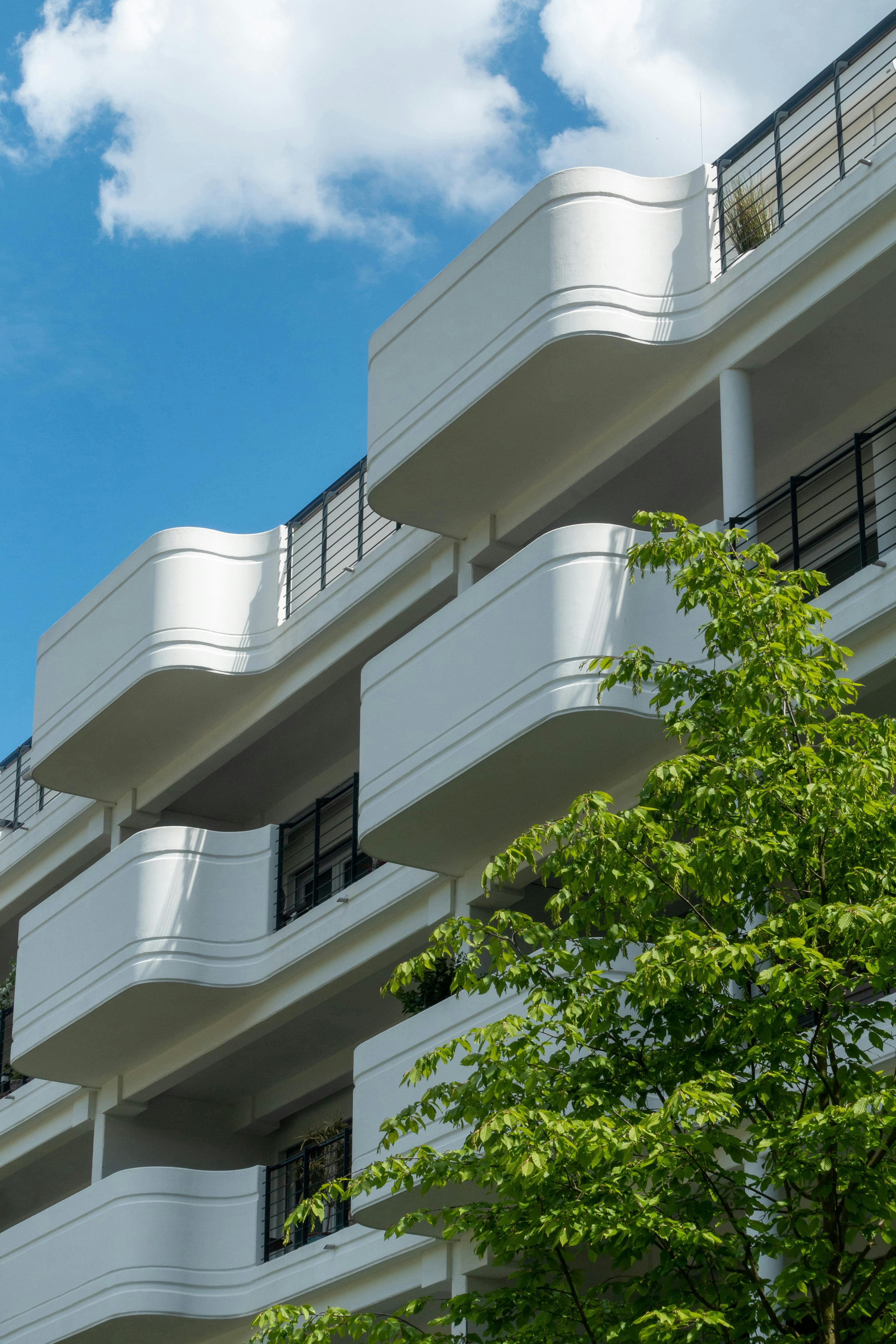 Low-angle view of a modern white apartment building with blue sky in Germany.