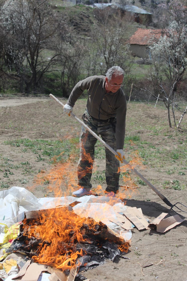 Man Burning Garbage In Countryside