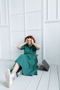 A Stressed Woman Touching Her Head while Sitting on the Wooden Floor