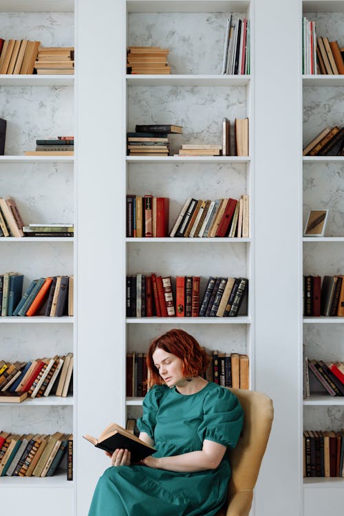 Free A Woman Reading Book in the Library Stock Photo