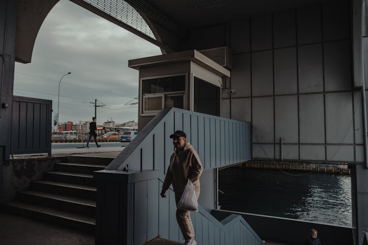 A Man In Sweater Walking Up The Stair