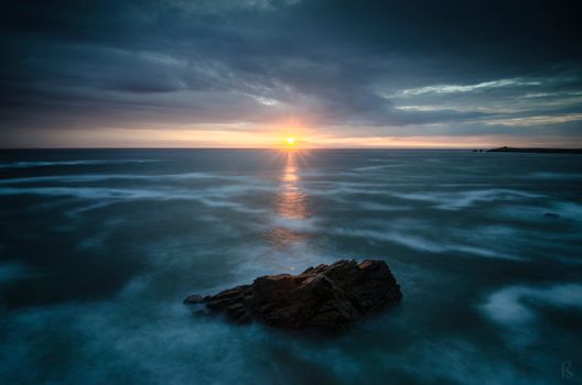 Dramatic sunset over the ocean in Quiberon, Bretagne, France with stunning rock formations.