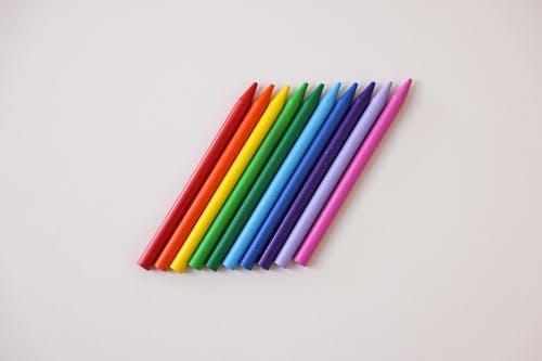 Free Row of Crayons on a White Surface Stock Photo