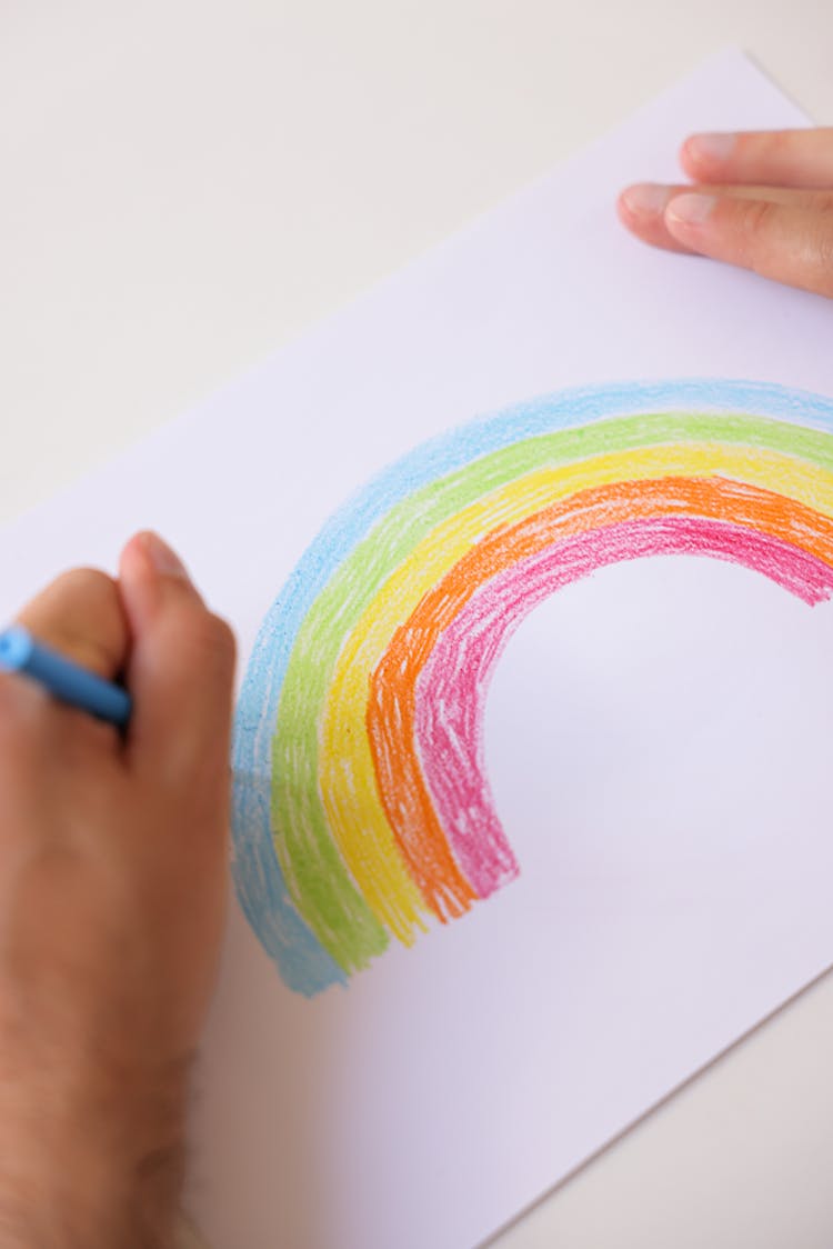 Person Drawing Rainbow On A Bond Paper