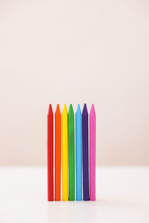 Free Vibrant set of crayons arranged vertically on a beige backdrop. Stock Photo