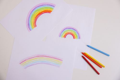 Free Vibrant crayon rainbow drawings on paper, viewed from above. Perfect for artistic and creative themes. Stock Photo