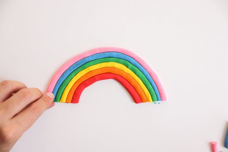 A Hand Holding The Rainbow Artwork Made Of Colorful Clays