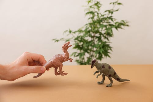 Hand Holding Miniature Dinosaur