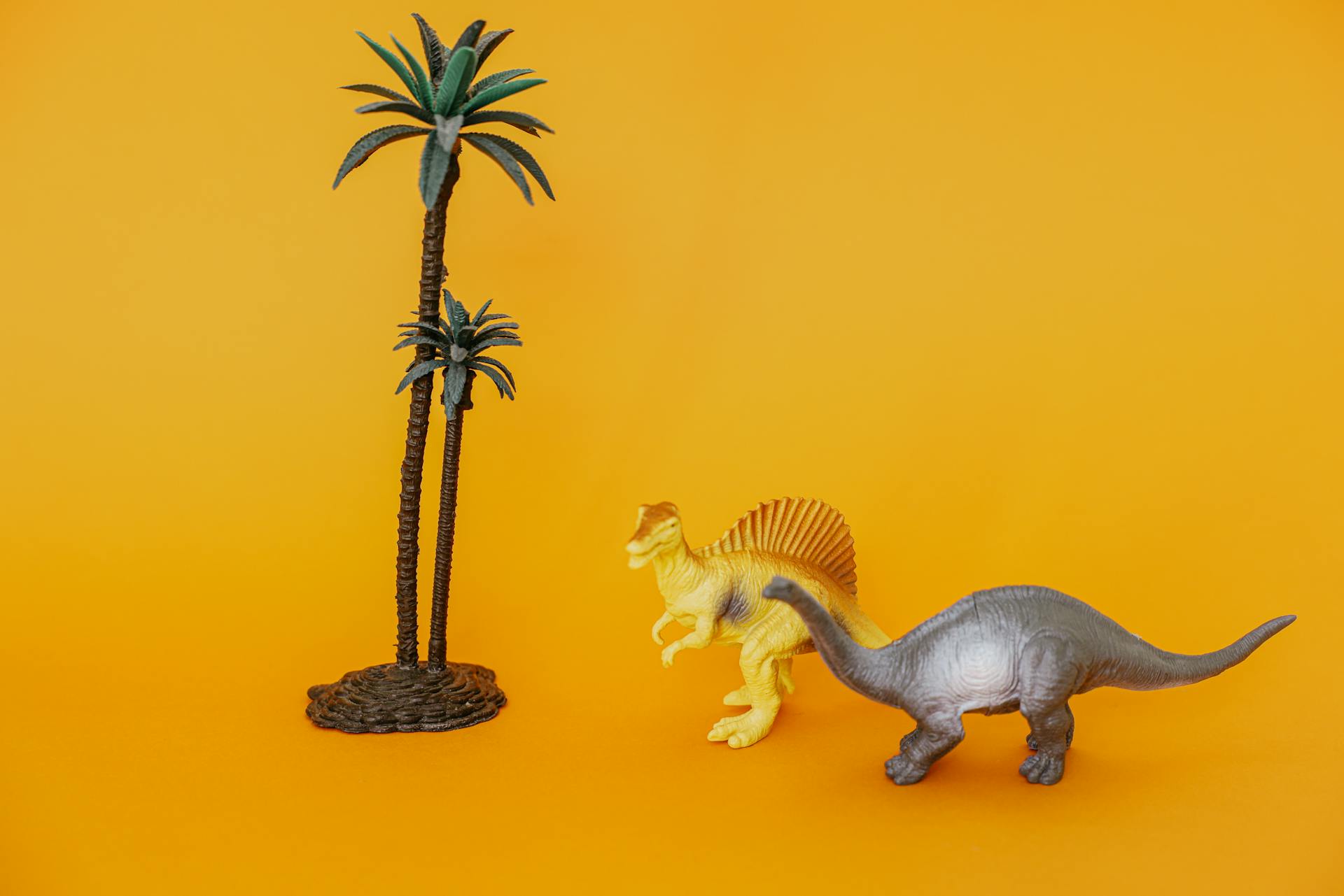 Miniatuurdinosaurierspeelgoed en bomen van plastic