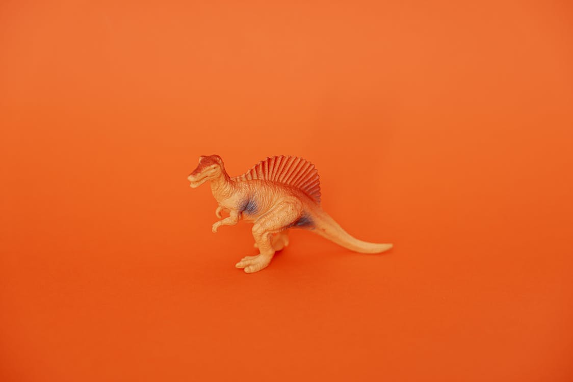 Dinosaur Toy Standing on Orange Background