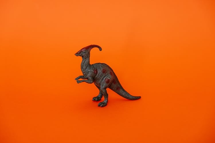 Dinosaur Figurine Against Orange Background