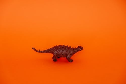 Plastic Dinosaur on Orange Background