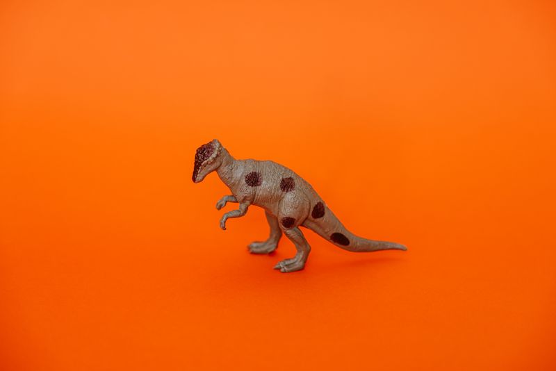 Dinossauro de brinquedo em fundo laranja