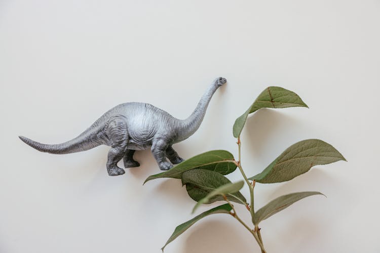 Grey Dinosaur Figurine On White Surface