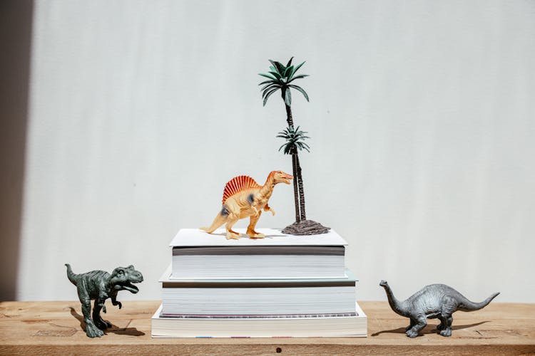 Plastic Dinosaur Toys Over And Near Books