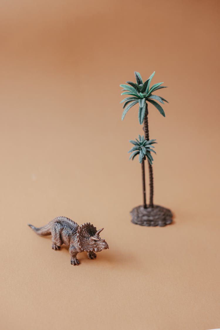 Plastic Toy Dinosaur And A Palm Tree 