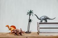 Gray Dinosaur Figurine Beside Brown Wooden Box