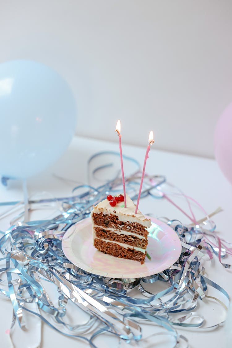 A Slice Of Cake With Lighted Candle