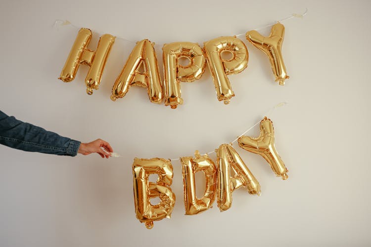 Person Hanging Birthday Decorations