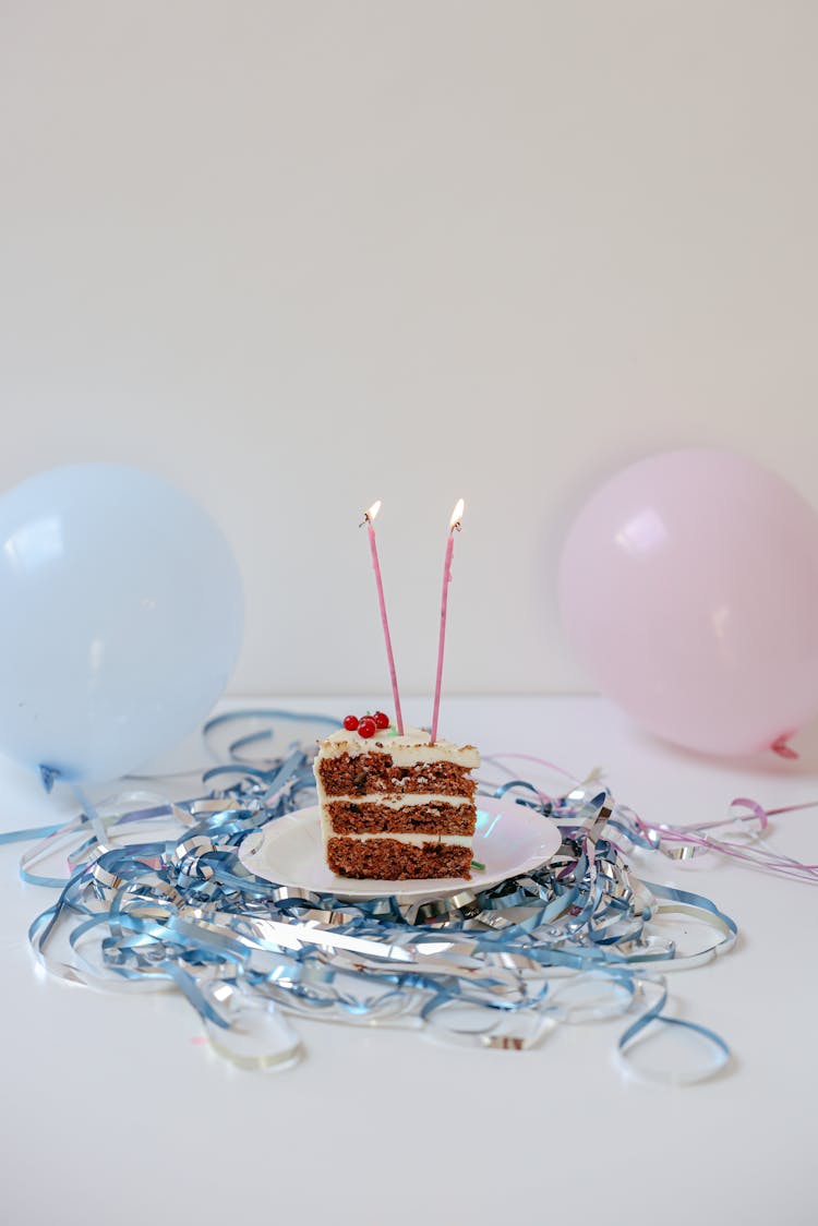 Lighted Candles On A Slice Of Cake