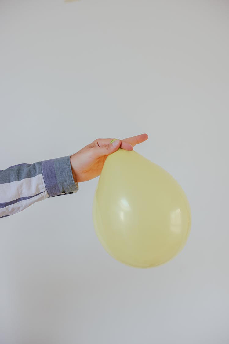 Person Holding A Yellow Balloon