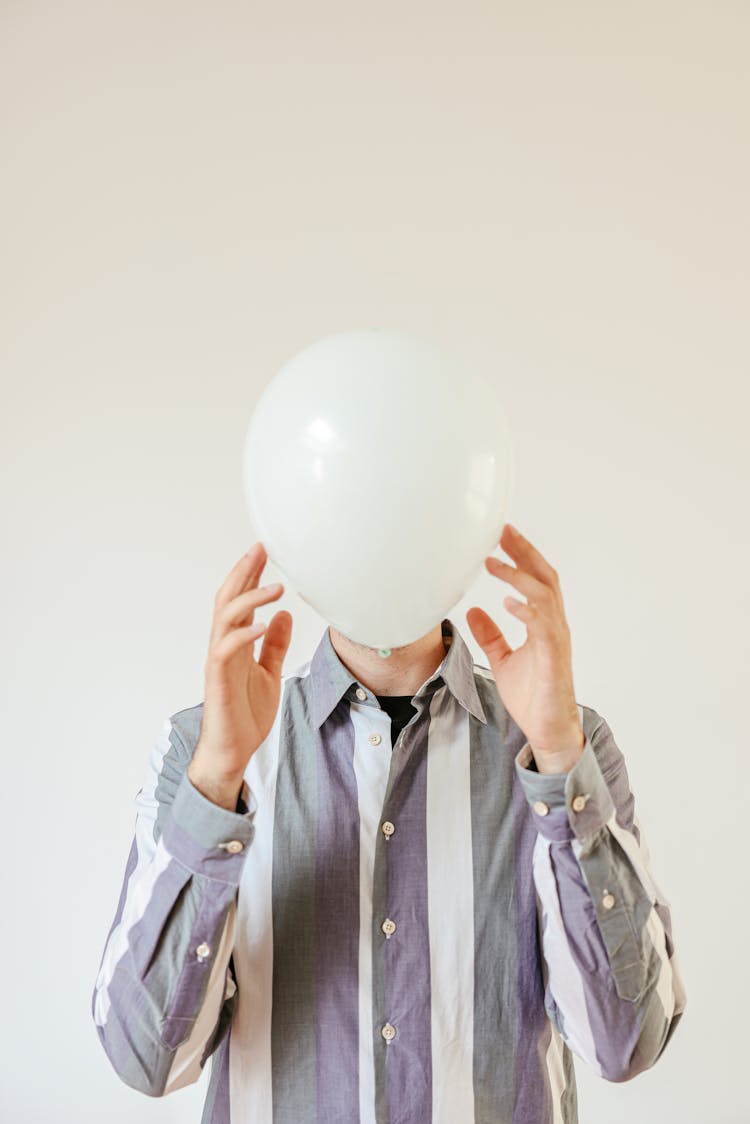 Person Covering Face With A White Balloon