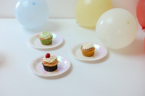Delicious Cupcakes on White Plates Near Balloons