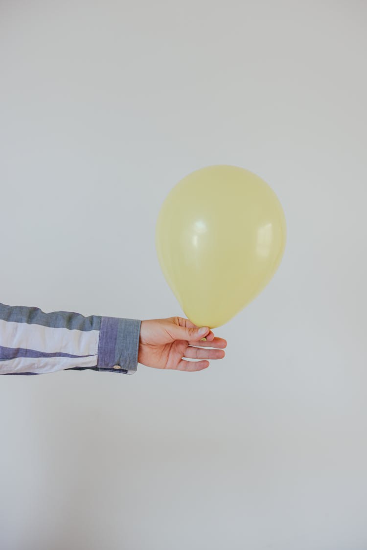 Person Holding A Yellow Balloon