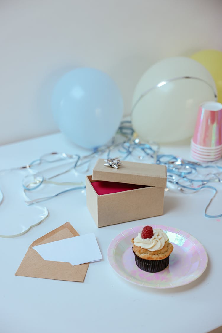 Opened Gift Box And A Cupcake On Paper Plate