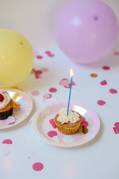 Free A Cupcake with Icing and Lighted Candle on Top Stock Photo