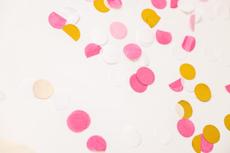 A Multi Colored Round Confetti On A White Surface