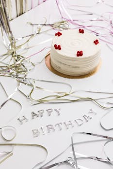 A close-up of a birthday cake with red decorations and silver ribbons, perfect for celebrations.