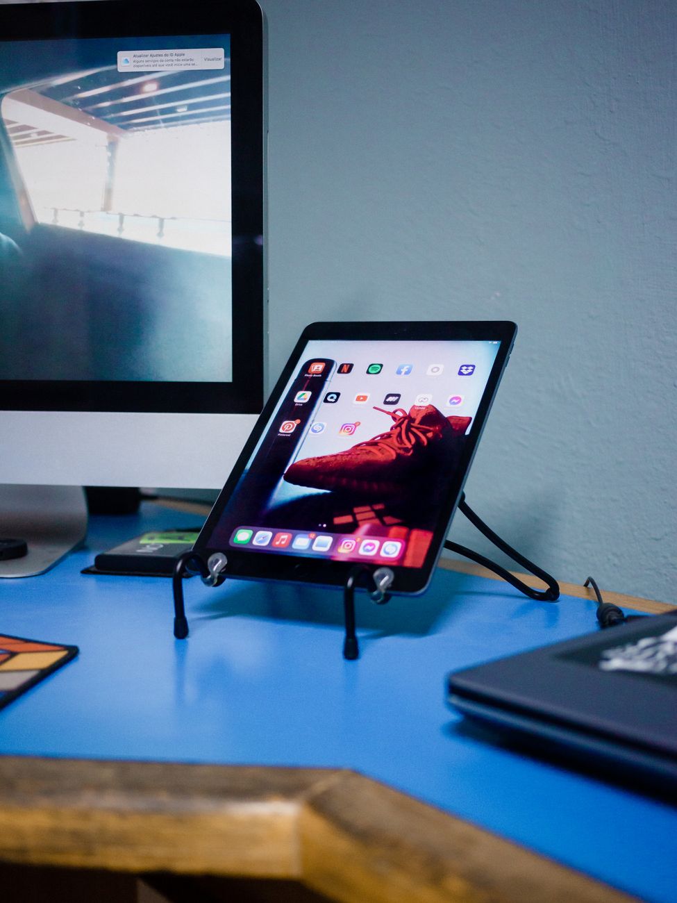 A modern workspace setup featuring a tablet on a stand and a desktop monitor in a well-lit room.