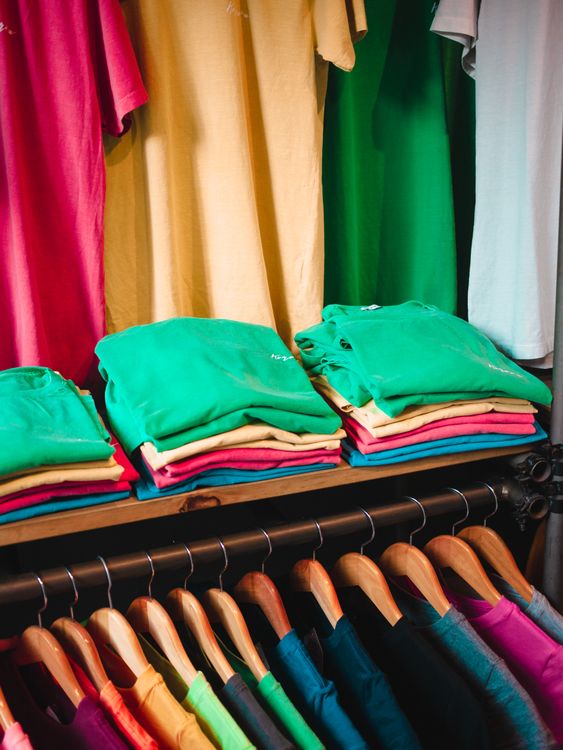 Neatly organized closet with colorful folded clothes and hanging garments