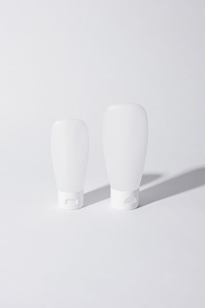 Unbranded white cosmetic tubes on a plain surface — photo by Cup of Couple on Pexels