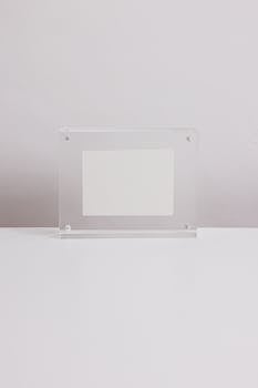 A simple, clear acrylic photo frame displayed on a clean, white background.