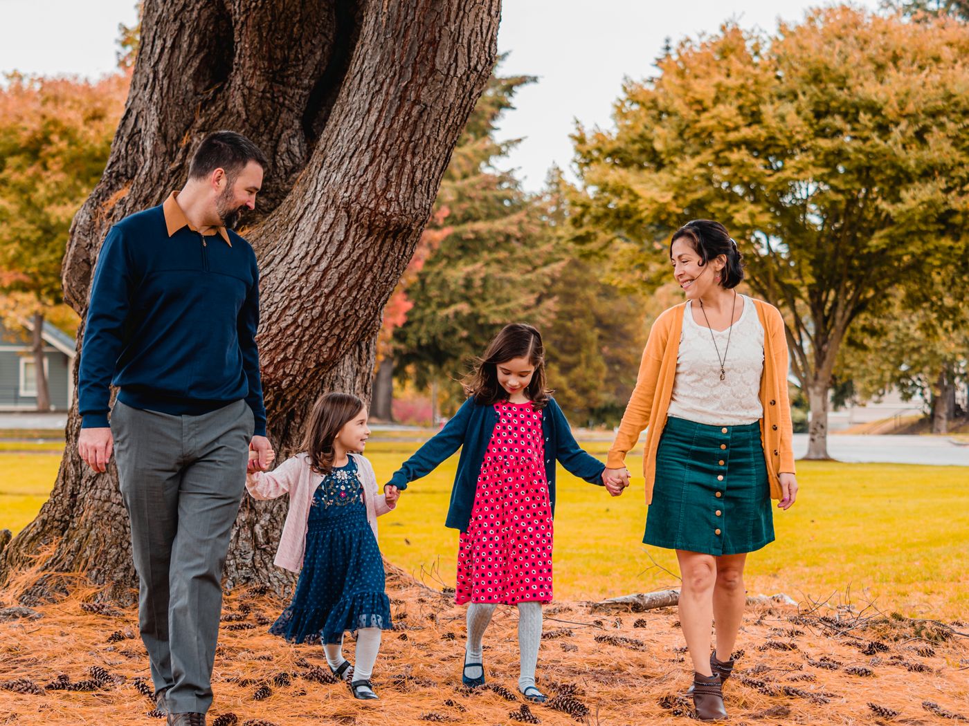 Parents and two children walking together through an autumn park