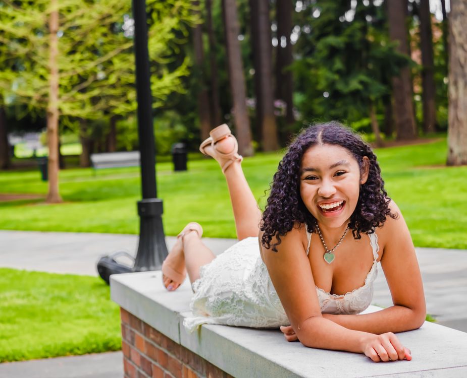 A Woman Lying on her Front on a Concrete Bench · Free Stock Photo