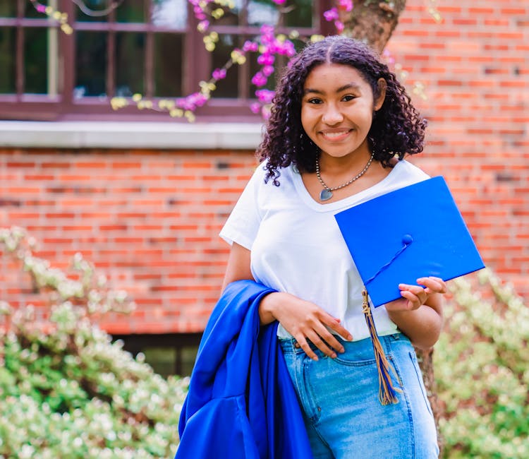 Woman Holding Blue Graduation Cap And Robe