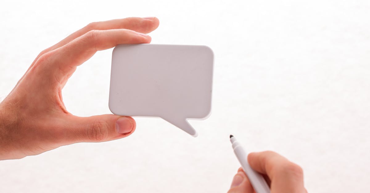 Minimalist image of hands holding a blank speech bubble and pen, perfect for creative mockups.