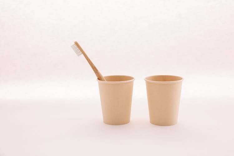 A Toothbrush In A Disposable Paper Cup