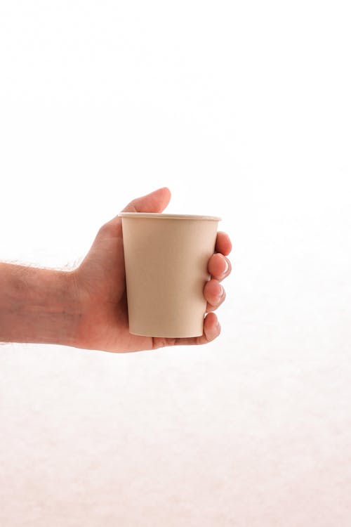 Close-up of a Person Holding a Paper Cup 