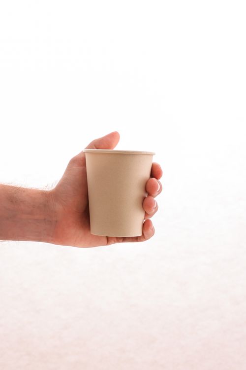 Free Close-up of a hand holding an eco-friendly paper cup, emphasizing sustainability. Stock Photo